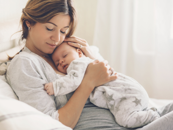Mama und ihr neugeborenens Baby im Wochenbett